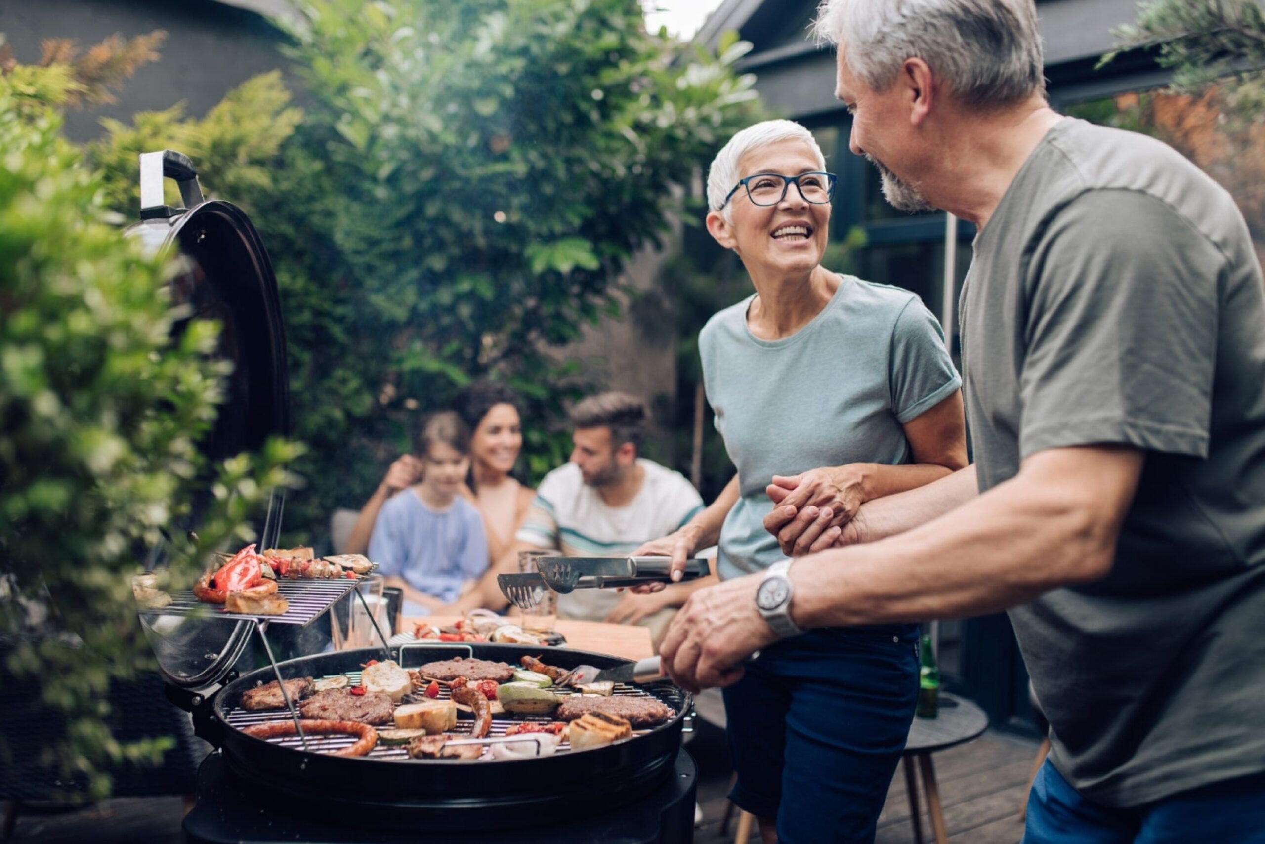 Happy couple enjoying making barbecue for their family